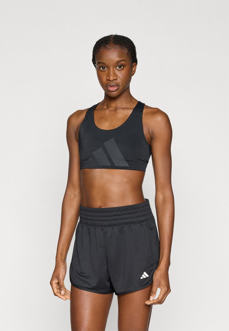 Μαύρο αθλητικό cropped τοπ με υφή δίχτυ και λογότυπο, σε συνδυασμό με μαύρο σορτς ψηλόμεσο με ελαστική μέση και λεπτομέρεια λογότυπου.