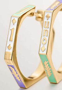 Pendientes de aro dorados con acentos de esmalte en tonos pastel de verde menta, lavanda y blanco. Los detalles incluyen números dorados y patrones de hojas.