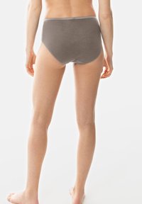 Bragas grises de cintura alta con textura acanalada y cinturilla elástica en contraste. Vista por la parte de atrás, sobre un fondo claro.