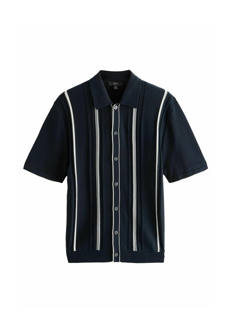 Polo de manga corta en azul marino con rayas verticales en contraste. Presenta un tejido texturizado, un collar estructurado y cierre de botones.
