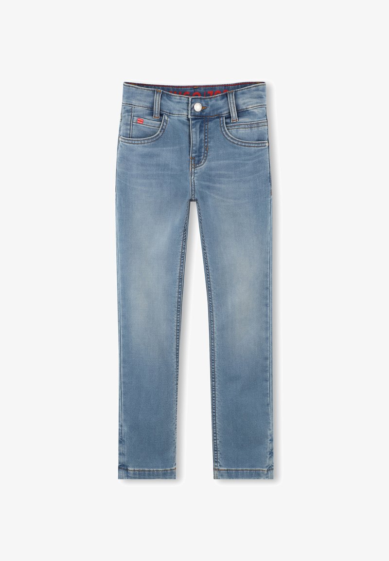 Jeans de mezclilla azul claro con un diseño ajustado. Presenta cinco bolsillos, un botón en la parte frontal y costuras en contraste. Textura suave con un ligero desgaste.