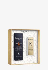 Kérastase haarverzorgingsgeschenkset met een marineblauwe en gouden gelabeled serumdoos en een gouden serumfles in een gouden doos met stippen.