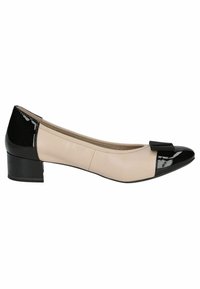 Zapato plano de cuero beige con punta y tacón en charol negro, que presenta un pequeño adorno de lazo negro en la parte frontal. Diseño de tacón bajo.