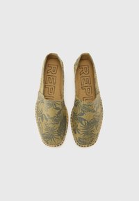Espadrile slip-on cu un model floral verde, material din pânză, și cusături contrastante pe margini. Interior maro cu logo-ul brandului.