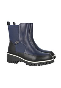 Botas de tobillo azul marino con un upper de cuero brillante y tejido texturizado, suela de goma negra y un acento de logo plateado en el lateral.
