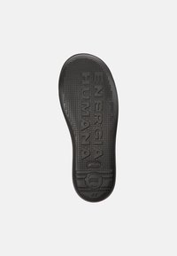 Black rubber shoe sole with textured surface, featuring the imprint "ENERGIA HUMANA" and circular logo. Size marked as 42.