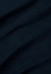 Tessuto di un blu navy scuro con texture rigata verticale e morbide pieghe che creano delicati ondeggi di luce e ombra.