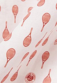 Weißer Stoff mit einem Muster aus kleinen orangen Tennisschlägern, gleichmäßig über die Oberfläche verteilt.