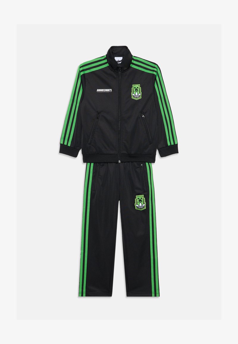 Černý sportovní teplákový komplet se zelenými pruhy. Obsahuje zipovou bundu se zipovými kapsami a logem Minecraft; kalhoty se sladěnými detaily loga.