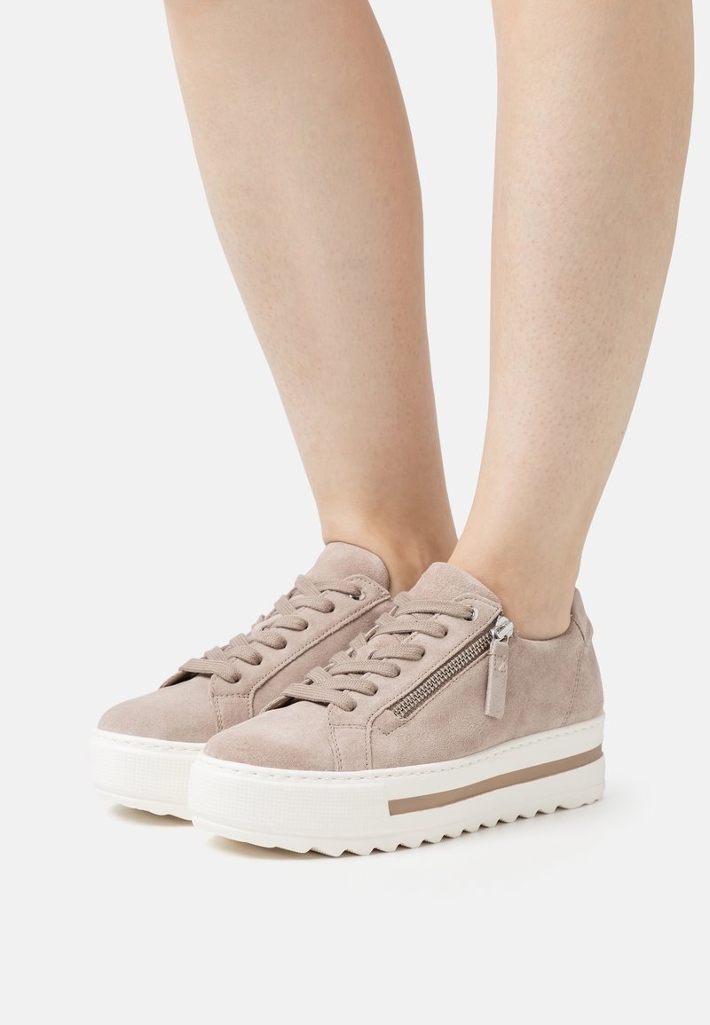 Mockaskinnssneakers i en ljusbeige färg, med snörning framtill, sidodragkedjeddetalj och tjock vit gummisula med texturerat grepp.