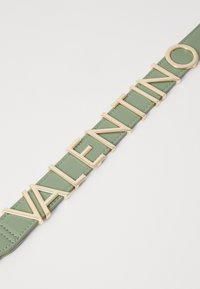 Ceinture en cuir vert ornée de lettres en métal doré formant le mot "VALENTINO" avec un accent circulaire ; texture lisse et design structuré.