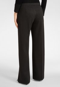 Schwarze gestreifte Hose mit hoher Taille, weitem Bein-Design und dezenten Falten auf der Rückseite. Glatte Stofftextur, minimalistische Details.