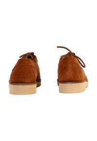 Zapatos de ante marrón con cordones y punta redondeada, que cuentan con una suela de goma de color claro y un sencillo detalle de costura en el talón.