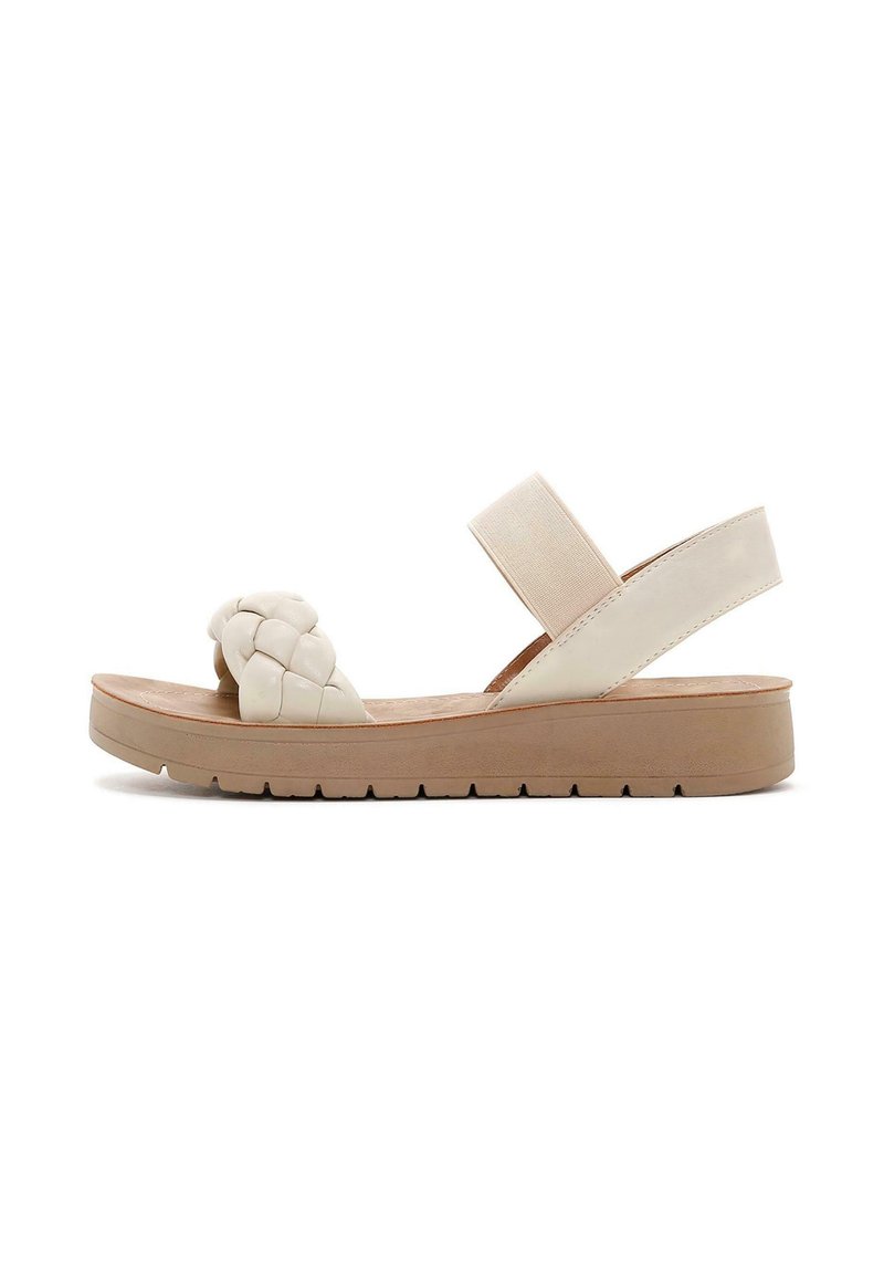 Sandalo intrecciato beige con una fascia elastica, suola piatta e materiale leggero e testurizzato. Presenta una finitura liscia e una leggera piattaforma.