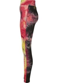Høytaljede leggings i et tie-dye mønster med røde, gule og svarte farger. Laget av elastisk stoff med en jevn tekstur.