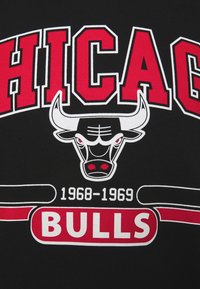 Tissu noir avec du texte rouge et blanc : "CHICAGO" au-dessus d'un logo de taureau et "BULLS" en dessous, avec "1968-1969" en blanc. Éléments de design audacieux et couleurs contrastées.