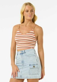 Un haut court rayé en rouge, orange et crème avec des fines bretelles, associé à une jupe en denim bleu clair présentant une poche cargo et un fermeture à bouton.