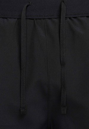 Bermudas deportivas negras con una textura suave, que cuentan con una cintura elástica con cordón y sutiles detalles de costura.