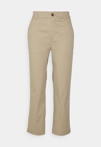 Pantalon beige à jambes droites avec passants de ceinture, bouton avant, braguette zippée et poches latérales, présenté sur un fond uni.