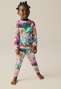 Ensemble de pyjama multicolore avec un motif de graffiti, manches longues et pantalons ajustés, fabriqué à partir d'un tissu doux au toucher lisse.