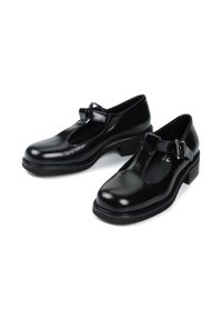 Czarne skórzane buty Mary Jane z tkaniną w kształcie litery T, zaokrąglonym noskiem i niskim słupkowym obcasem. Posiadają akcent w postaci klamry na pasku.