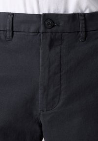 Dark gray cotton trousers featuring a smooth texture, a single button closure, and a side pocket. Stitched detailing is visible along the seams.