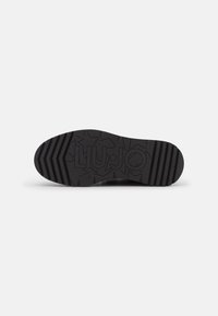 Suela de zapato negra con patrones de estrellas y el nombre de la marca "LIU JO" grabado en la banda de rodadura, talla 37, sobre un fondo blanco.