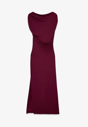 Pitkä mauven värinen mekko, joka on valmistettu pehmeästä ja joustavasta kankaasta. Varustettu roikkuvalla kaula-aukolla ja sivuhalkiolla liikkumisen helpottamiseksi. Koko mekossa on sileä pinta.