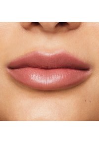 Lèvres pulpeuses avec une finition mate dans une teinte rose poussiéreuse. La texture de la peau est lisse avec des variations subtiles. Pas de motifs ou d'accents visibles.