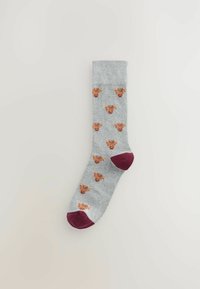 Graue Socken mit braunem Tiermuster, geripptem Bündchen und akzentuierten marsalafarbenen Zehen und Fersen. Gestrickte Textur mit einem verspielten Design über die gesamte Socke.