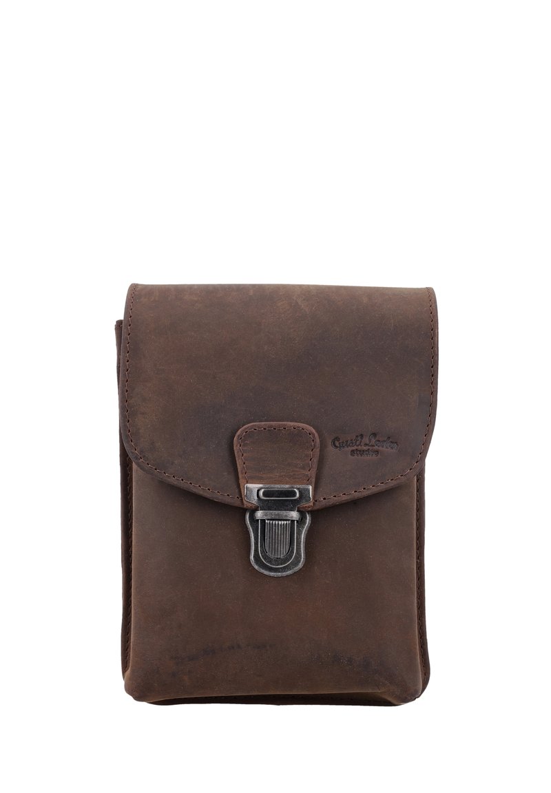 Brązowa skórzana torba z klapką, z metalowym zapięciem i wytłoczonym logo. Gładka tekstura z niewielkimi śladami zużycia, kompaktowy design.