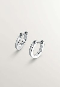 Pendientes de aro de plata con una superficie lisa y pulida, que presentan un diseño circular compacto y una bisagra ligeramente abierta para el cierre.