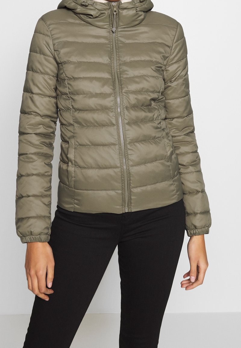 Oliwkowa puchowa kurtka z zamkiem z przodu, kapturem i elastycznymi mankietami. Charakteryzuje się poziomym pikowaniem i gładką teksturą nylonu.