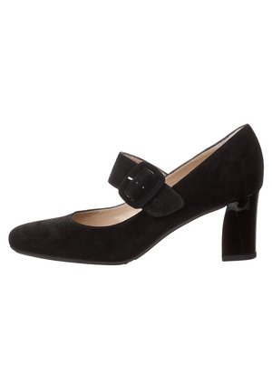 Chaussure noire en suede de style Mary Jane avec un embout carré, un talon moyen et une sangle ajustable à boucle sur le cou-de-pied, doublure intérieure lisse.