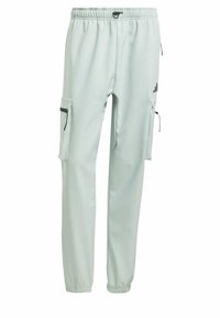 Lichtgroene sportbroek met een elastische tailleband, ritszakken aan de zijkanten en een zwart logo-accent op de dij.