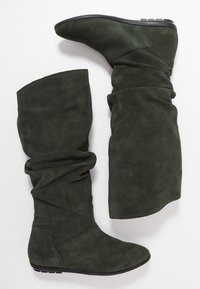 Vihreät mokkanahkaiset polvipituiset saappaat, joissa on rento muotoilu, pyöreä kärki ja matala korko. Sileä pinta, jossa on vähäiset yksityiskohdat.