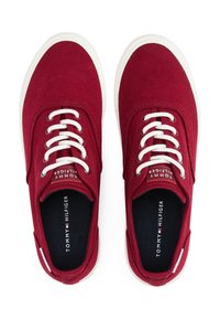 Punaiset kangaskengät valkoisilla nauhoilla ja kumipohjilla. Sisältää logon sisäpohjassa ja kantapäässä, pyöreä kärki ja teksturoitu päällinen.