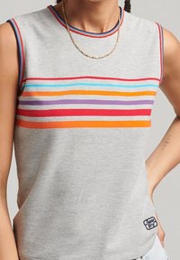 Šedý tílko s vodorovnými pruhy v červené, oranžové, fialové a modré barvě. Má žebrovaný výstřih a malou logo na spodním pravém okraji.