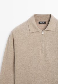 Beżowy sweter dziany z zamkiem przy kołnierzu, wykonany z miękkiej wełny, o teksturowanej powierzchni i metce Massimo Dutti.