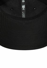 Schwarze Baseballmütze aus glattem Stoff mit einem gebogenen Schirm, ausgestattet mit Belüftungslöchern und einem inneren Etikett mit Markeninformationen.