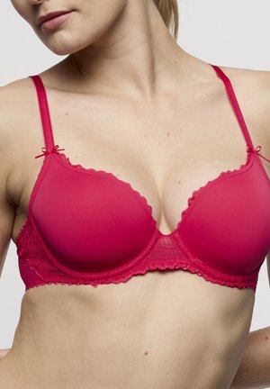 Rode gevoerde beha met kanten rand en strikjes op de bandjes. Soepele textuur, verstelbare bandjes en een driehoekige cupvorm.