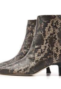 Knöchelhohe Stiefel aus Schlangenhaut mit spitzer Zehenpartie, die ein Muster aus Dunkelbraun, Beige und Schwarz aufweisen, auf einem niedrigen Blockabsatz gesetzt.