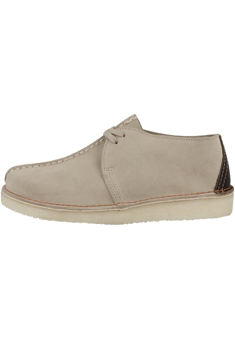 Ljus beige mockaskor med rund tå, minimalistic design, kontrasterande mörkbrun klackflik och beige gummisula. Knytningar framtill.