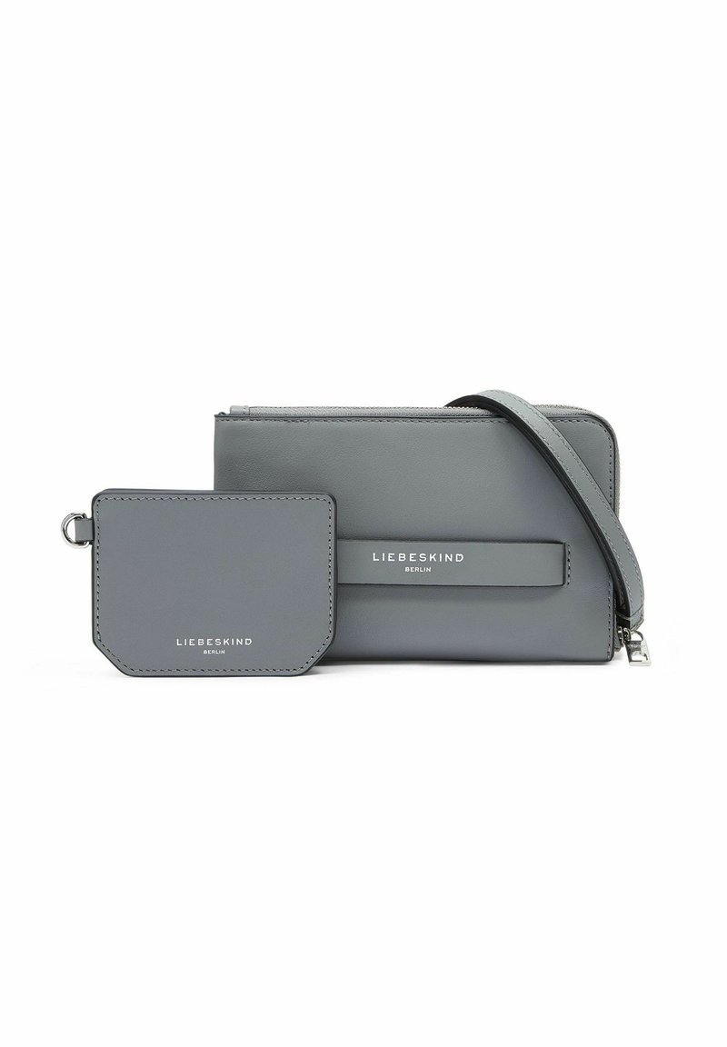 Portefeuille en cuir gris avec un porte-cartes amovible. Comprend une fermeture éclair, une sangle plate et des détails de marque embossés en argent.