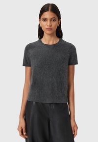 Mørkegrå kortærmet sweater lavet af blødt, fluffy materiale med rund halsudskæring og en afslappet pasform. Sammen med sorte læderbukser.