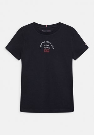 Schwarzes T-Shirt mit kurzen Ärmeln und Rundhalsausschnitt mit dem Schriftzug "Tommy Hilfiger New York" und einem kleinen rot-weißen rechteckigen Logo unter dem Text.