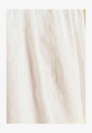 Tessuto di lino leggero in morbido bianco con una sottile trama, caratterizzato da una qualità leggermente trasparente e un drappeggio naturale e traspirante.