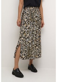Jupe midi en motif léopard en tissu léger avec une taille élastique et des fentes latérales. Assortie à des mocassins noirs pour un contraste.