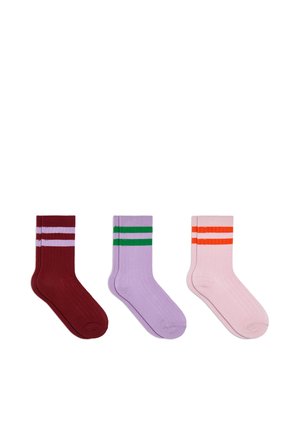 Trois paires de chaussettes montantes côtelées en rouge avec des rayures roses, en violet avec des rayures vertes et en rose avec des rayures orange, affichées côte à côte.