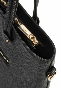 Czarna skórzana torba tote z teksturowanym wykończeniem, złotymi elementami, górnym zamknięciem na zamek błyskawiczny oraz boczną kieszenią na zamek. W zestawie uchwyty oraz odpinany pasek.